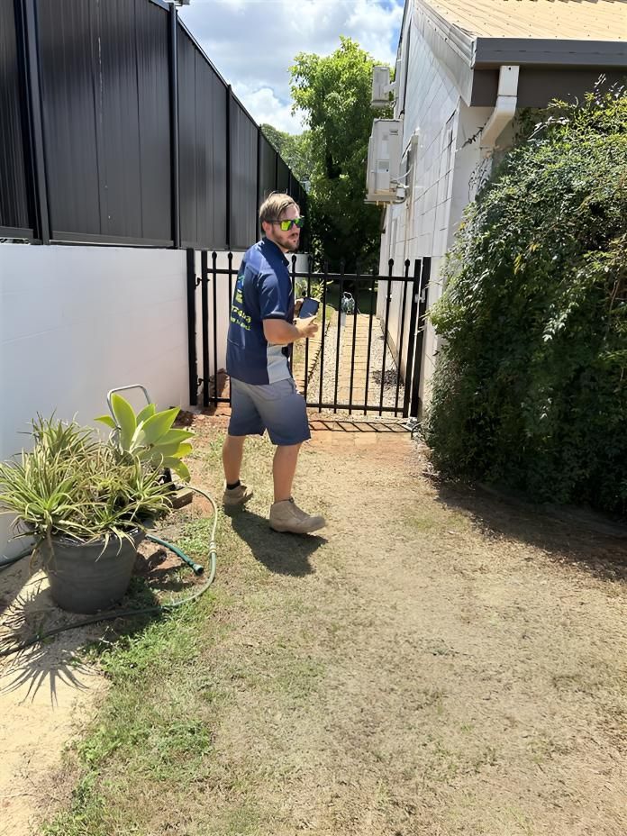 Man is Standing in Front of a Fence in a Yard — Youfi Fixit Handyman Services in Edmonton, QLD