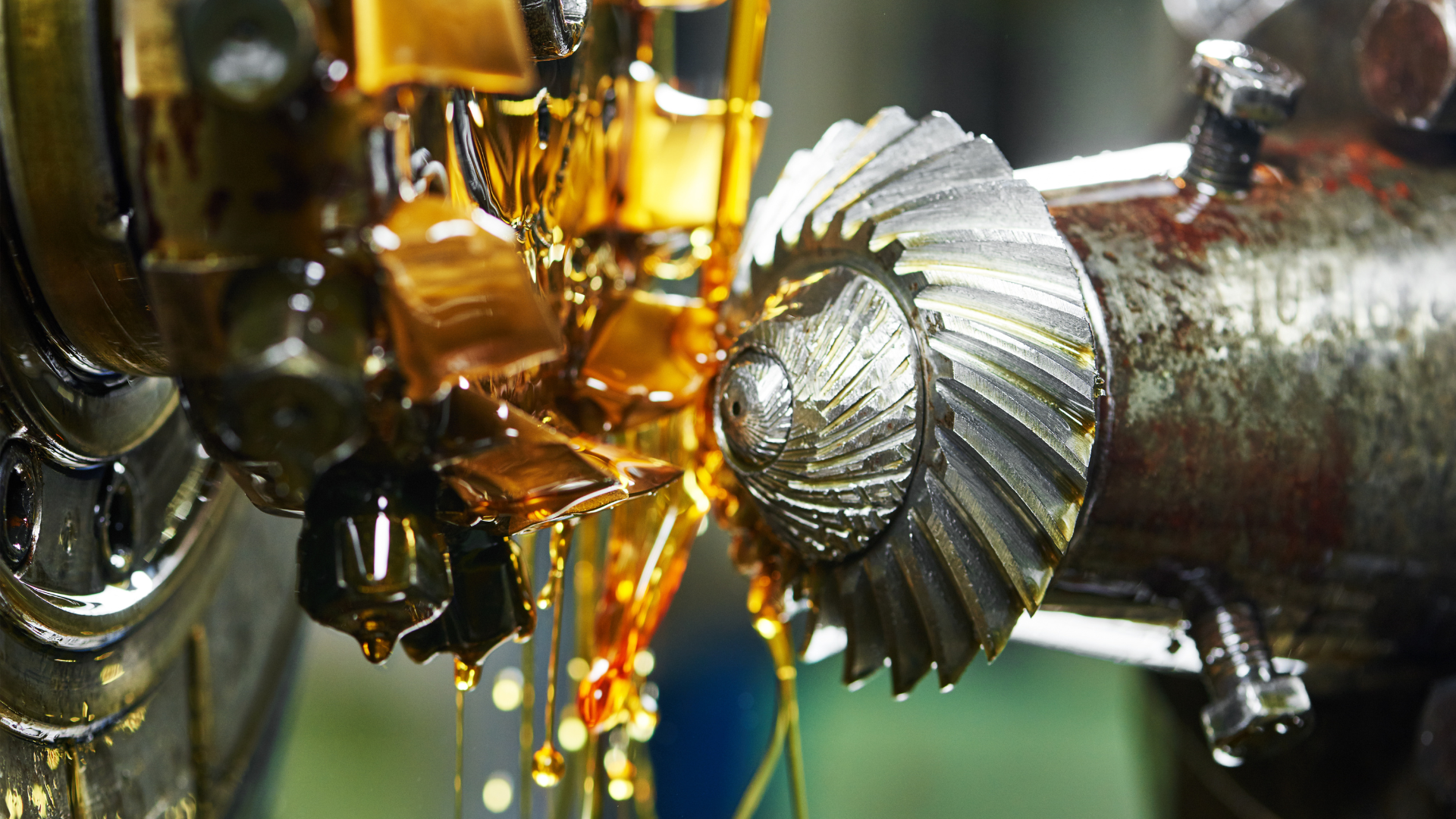 A close up of a machine pouring oil on a gear.