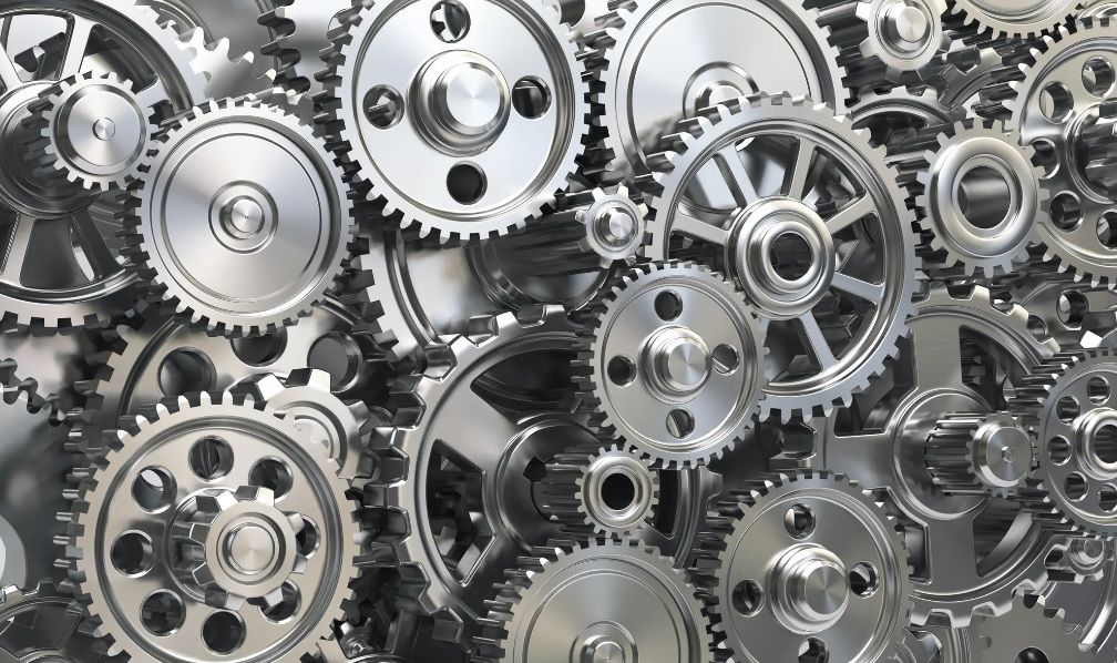 A close up of a machine pouring oil on a gear.