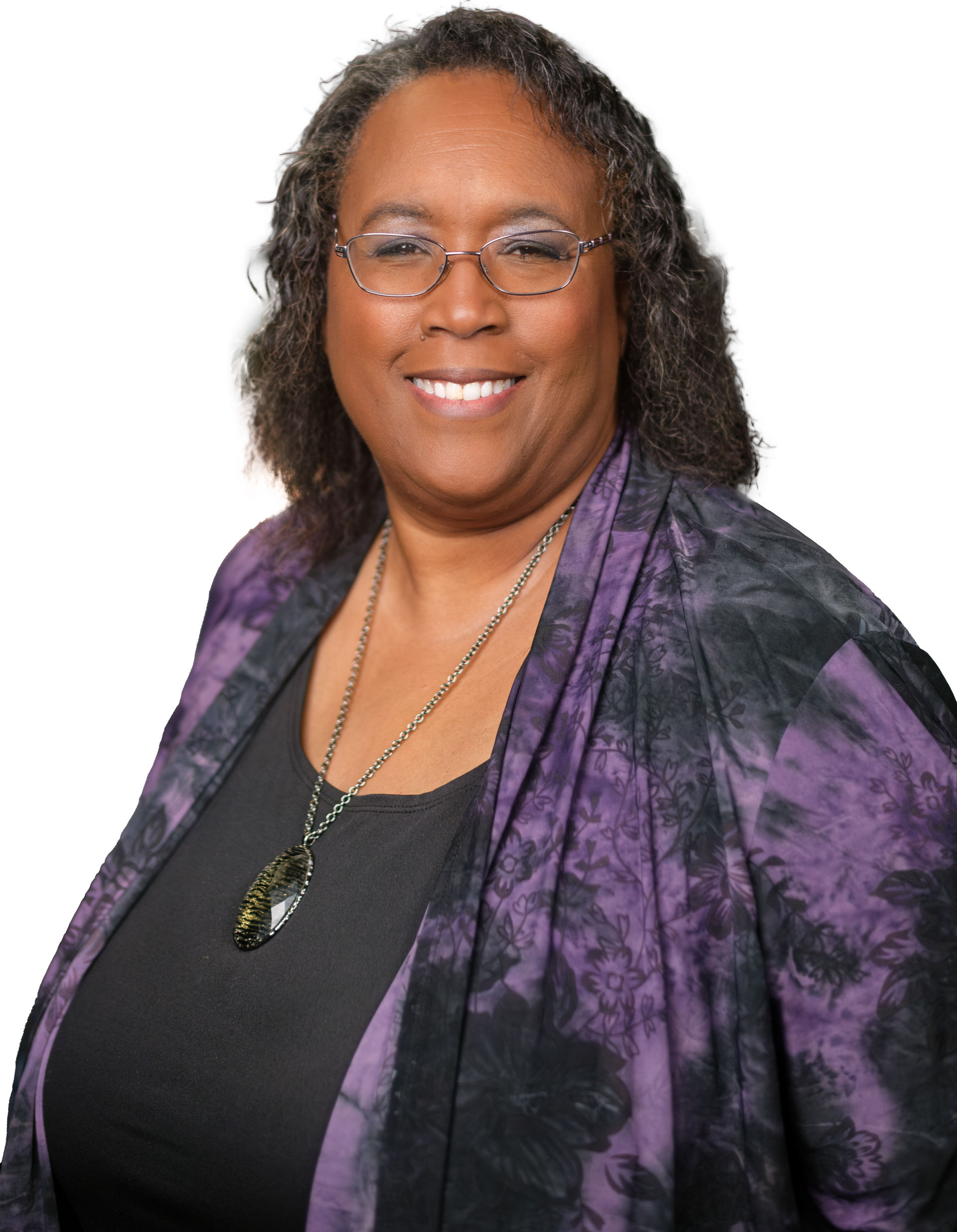 A woman wearing glasses and a purple jacket smiles for the camera