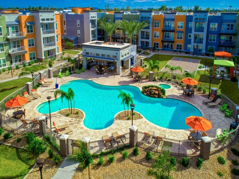 An aerial view of a large swimming pool surrounded by umbrellas and chairs
