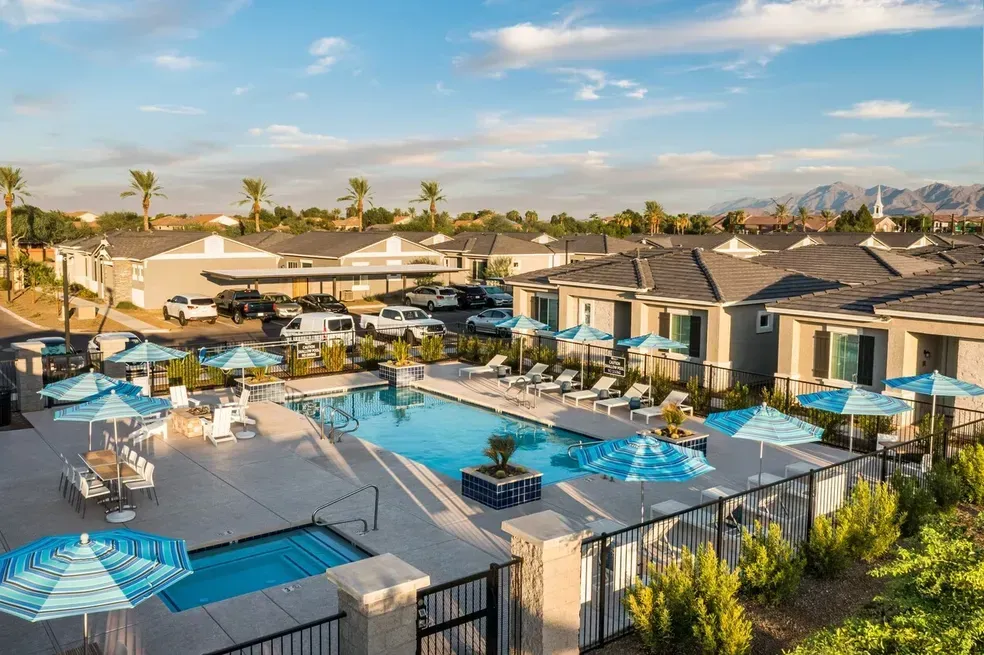 An aerial view of a large swimming pool surrounded by umbrellas and chairs.