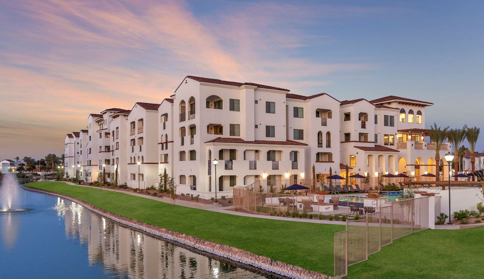 A large white building is sitting next to a body of water.