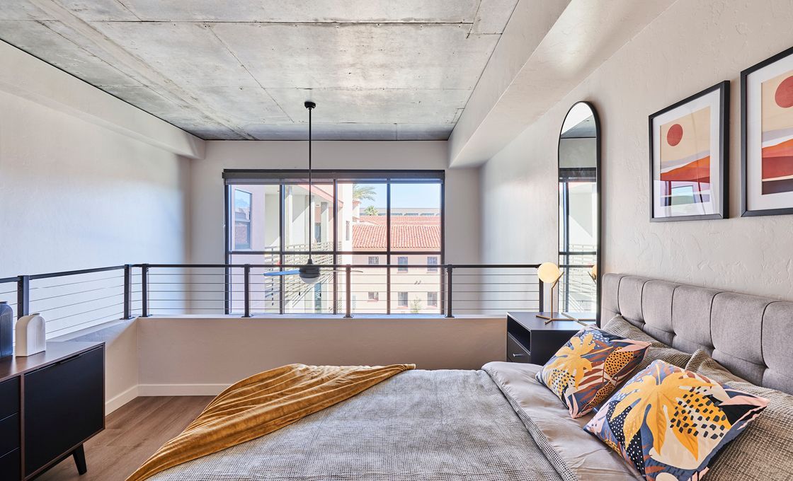 A bedroom with a large bed and a large window.