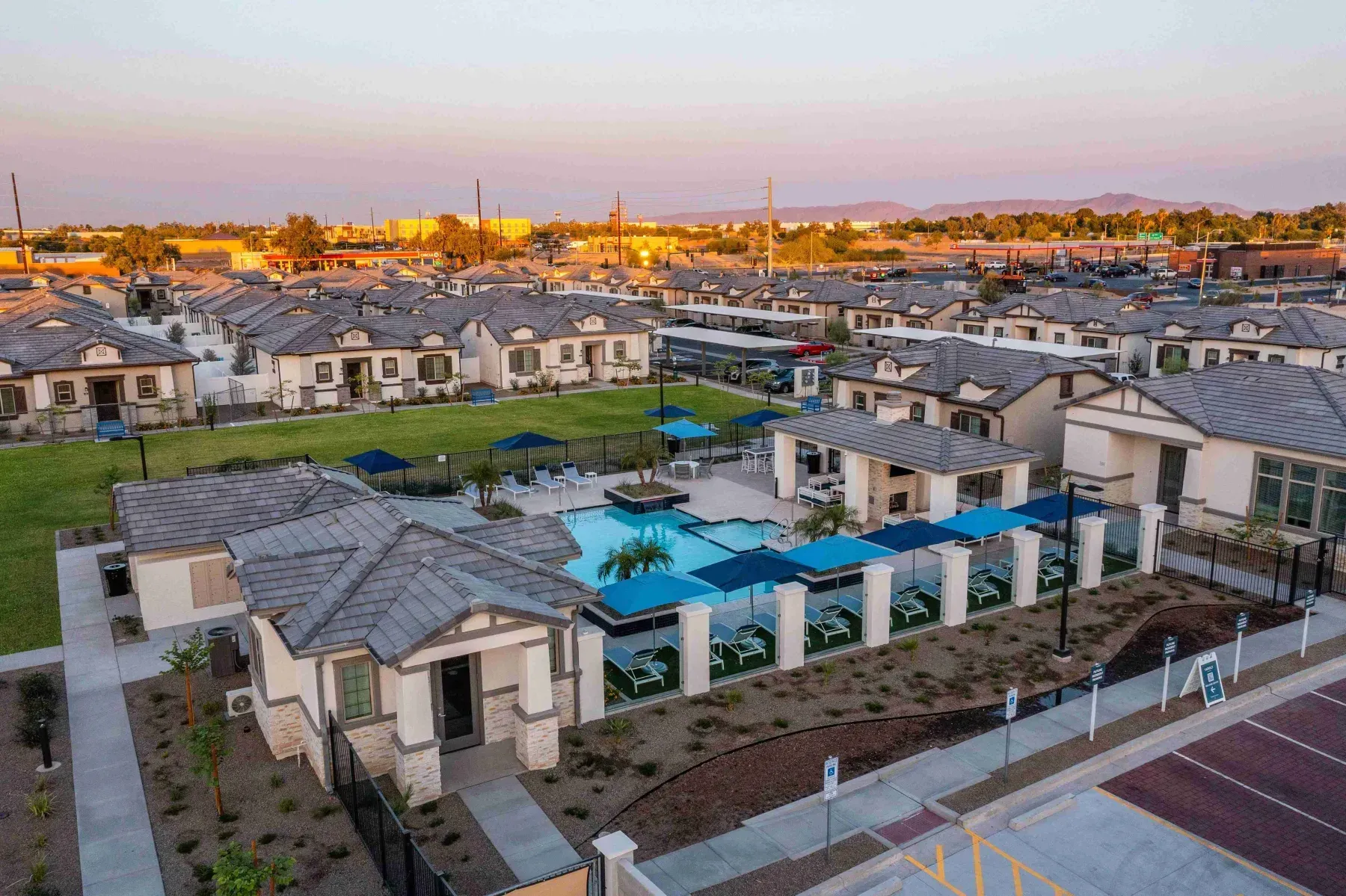 An aerial view of a residential area with a pool and umbrellas.