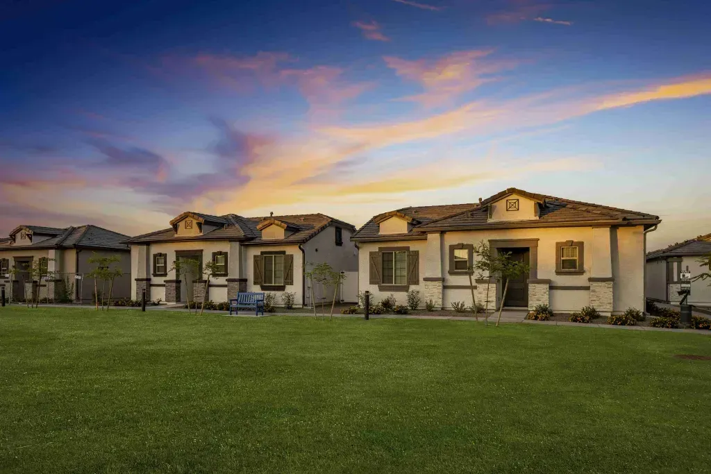 A row of houses sitting on top of a lush green field.