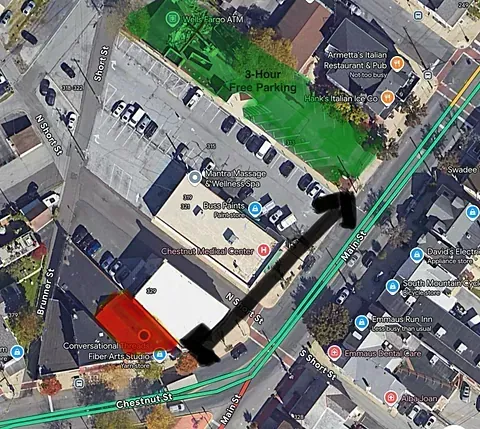 Aerial map with highlighted route through city blocks, marked in green and black over buildings and streets