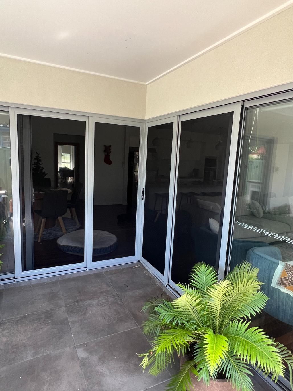 A Patio With Sliding Glass Doors And A Potted Plant — Glass 24/7 In Taree, NSW