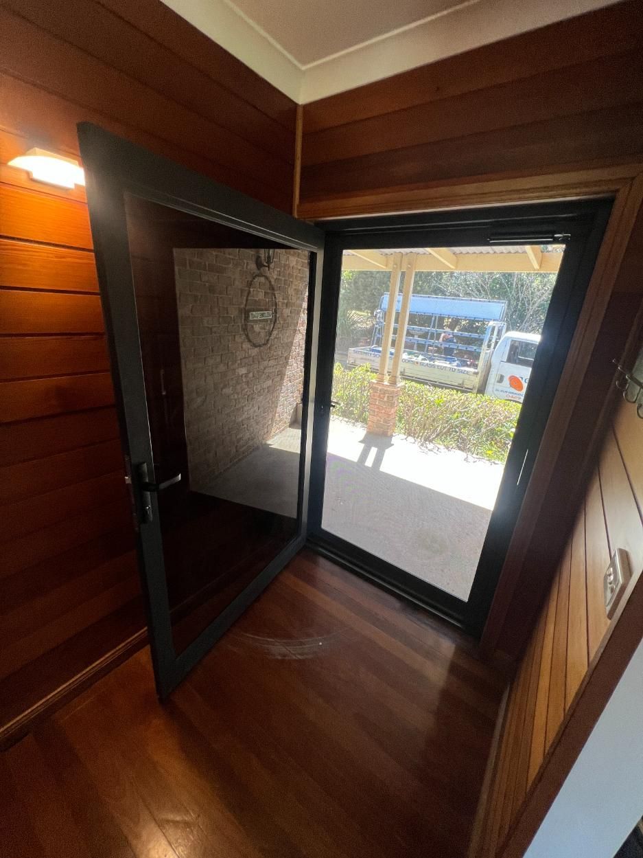 A Room With A Sliding Glass Door And A Wooden Wall — Glass 24/7 In Taree, NSW
