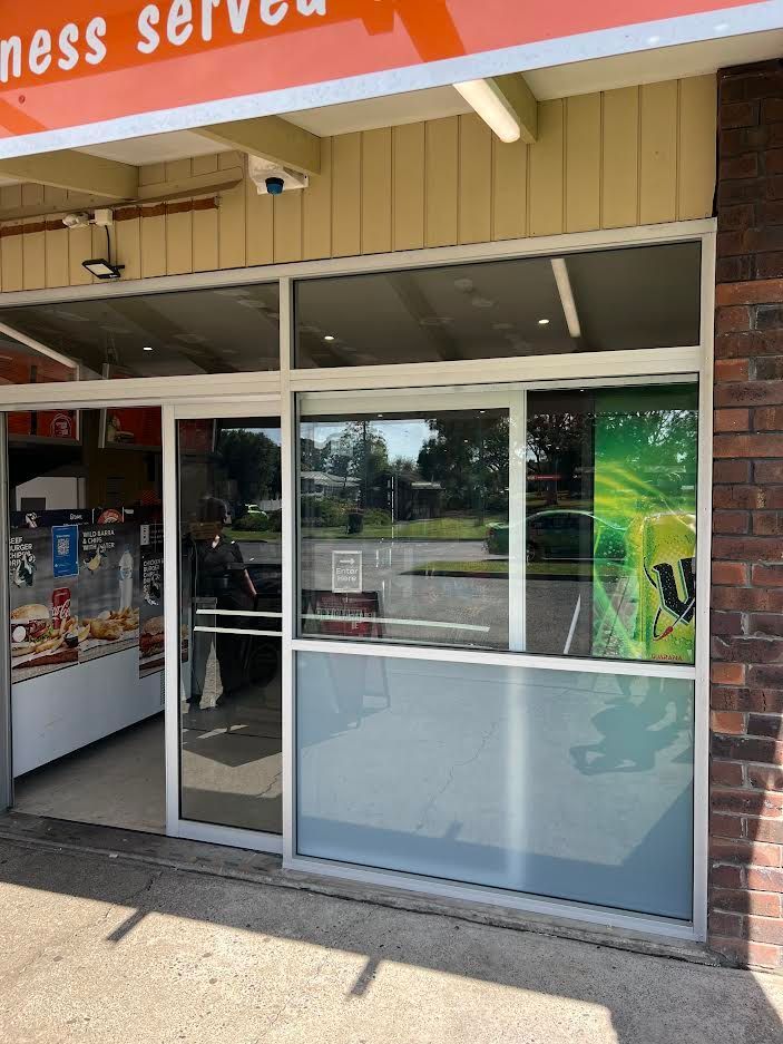 A Store Front With A Sliding Glass Door And A Sign That Says Ness Served — Glass 24/7 In Taree, NSW
