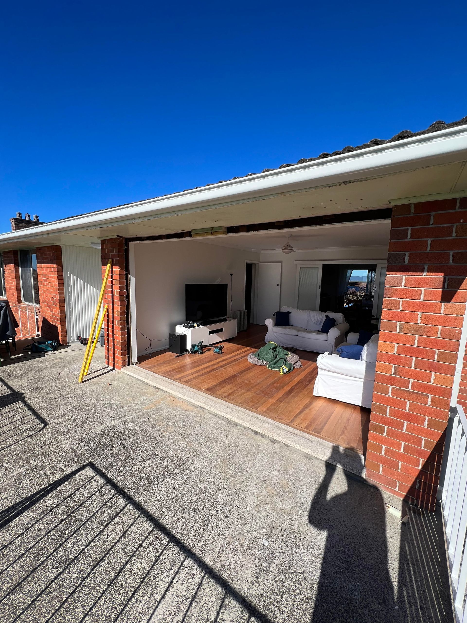 A living room with a couch and a television on the roof of a house — Glass 24/7 In Taree, NSW