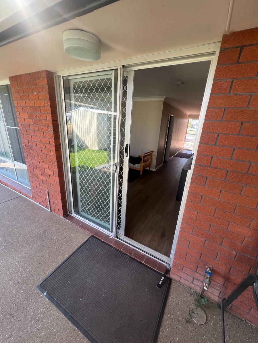 A Sliding Glass Door Is Open To A Living Room — Glass 24/7 In Taree, NSW
