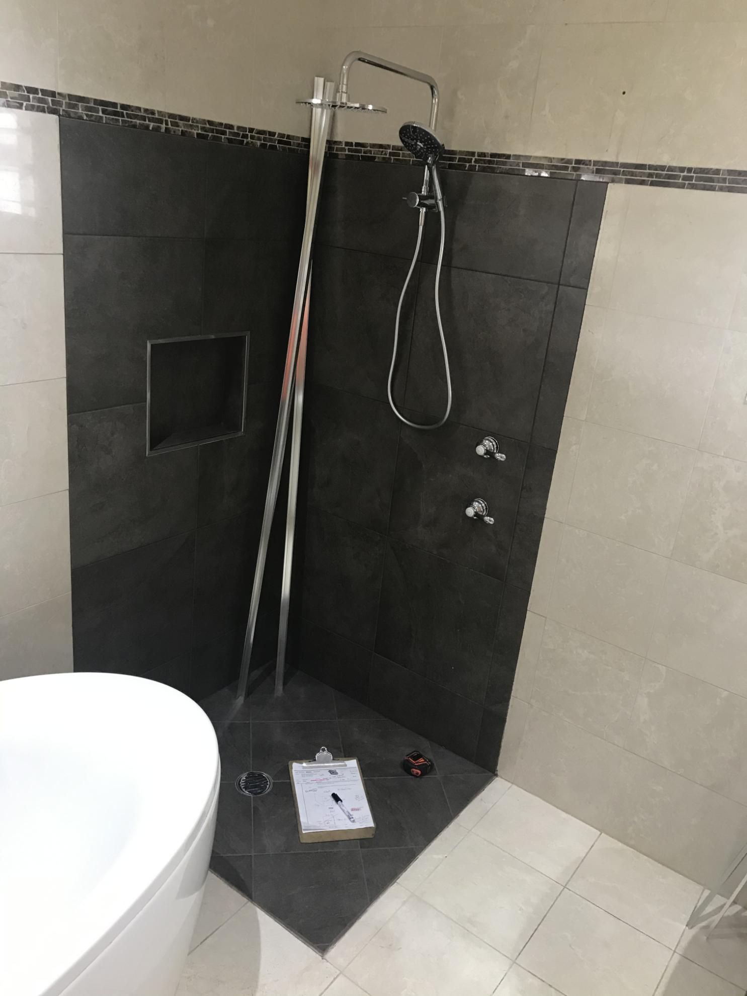 A Bathroom With A Toilet And A Shower With A Clipboard On The Floor — Glass 24/7 In Taree, NSW