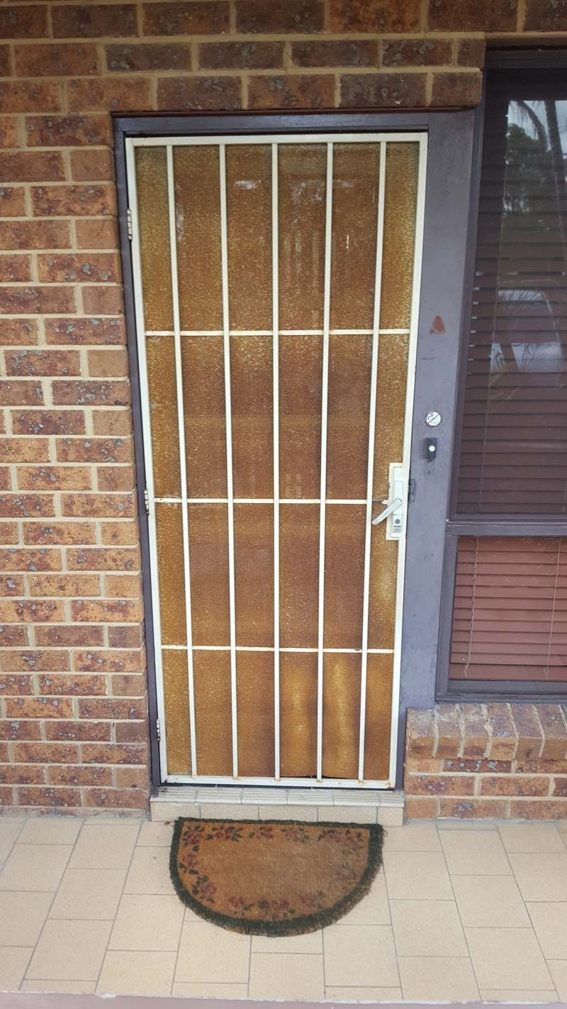 A Brick Building With A Door With A Metal Grill On It — Glass 24/7 In Old Bar, NSW