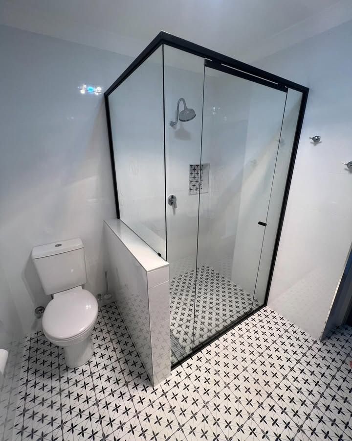 A Bathroom With A Toilet, Shower And Black And White Tiles — Glass 24/7 In Gloucester, NSW