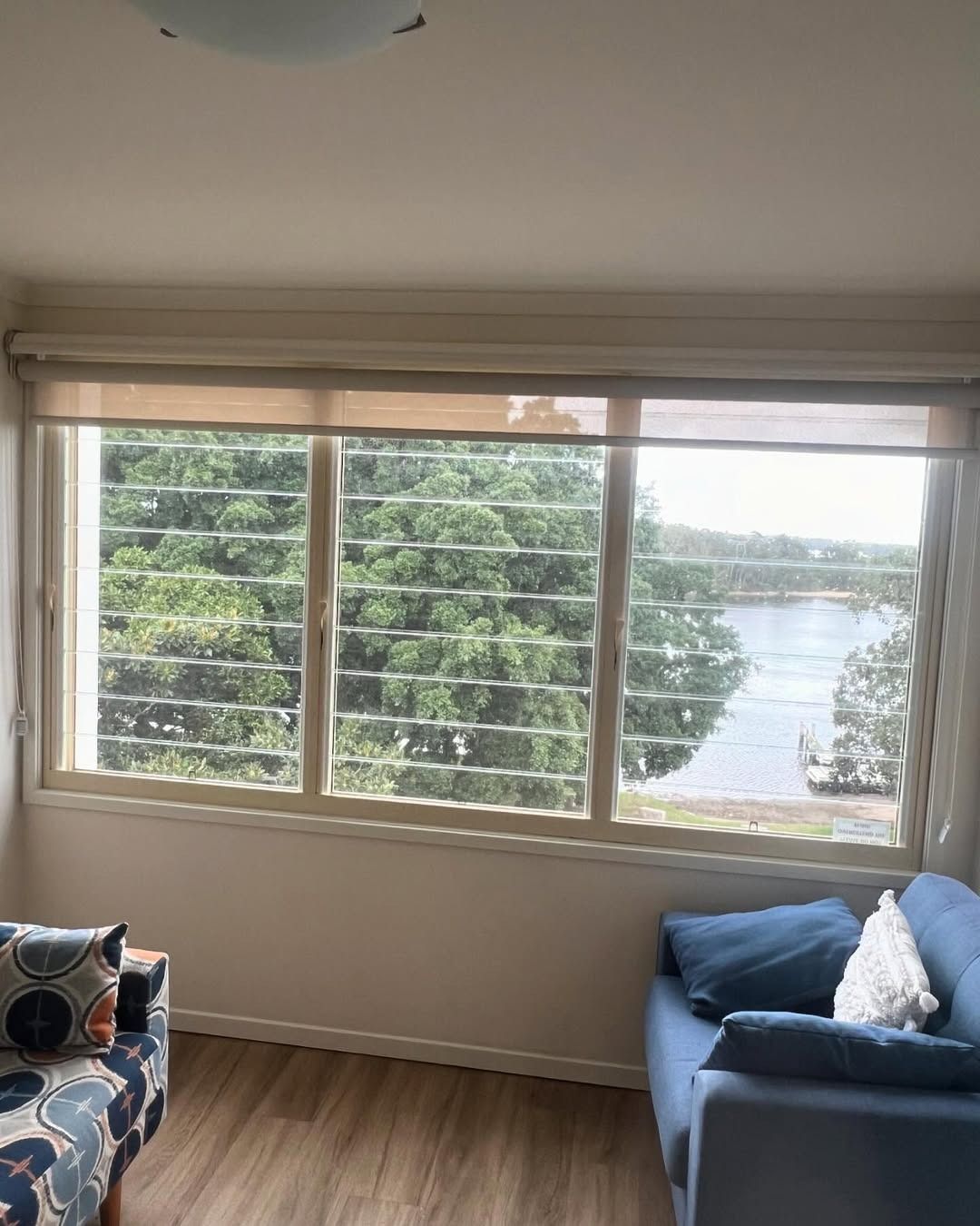 A Living Room With A Couch And A Large Window With A View Of A River — Glass 24/7 In Gloucester, NSW
