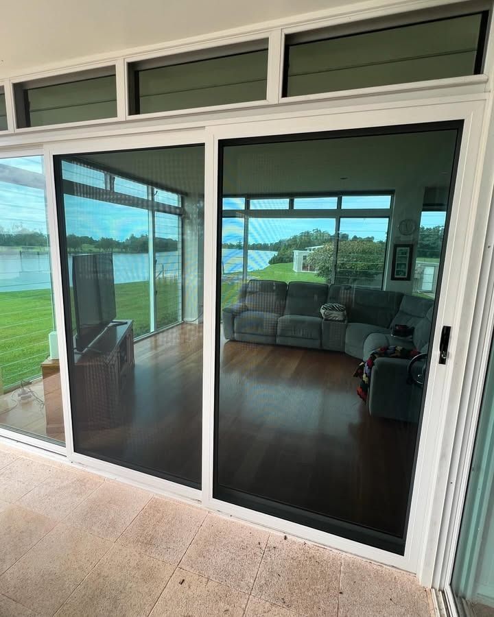 A Living Room With Sliding Glass Doors And A Couch — Glass 24/7 In Gloucester, NSW