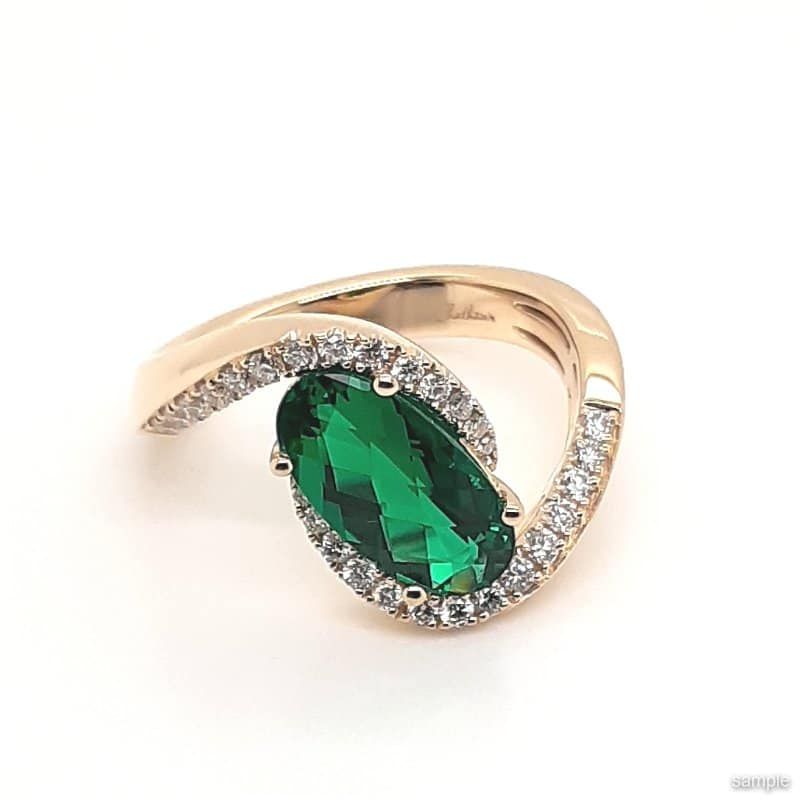 Gold ring with a large oval green gemstone and surrounding halo of small diamonds.