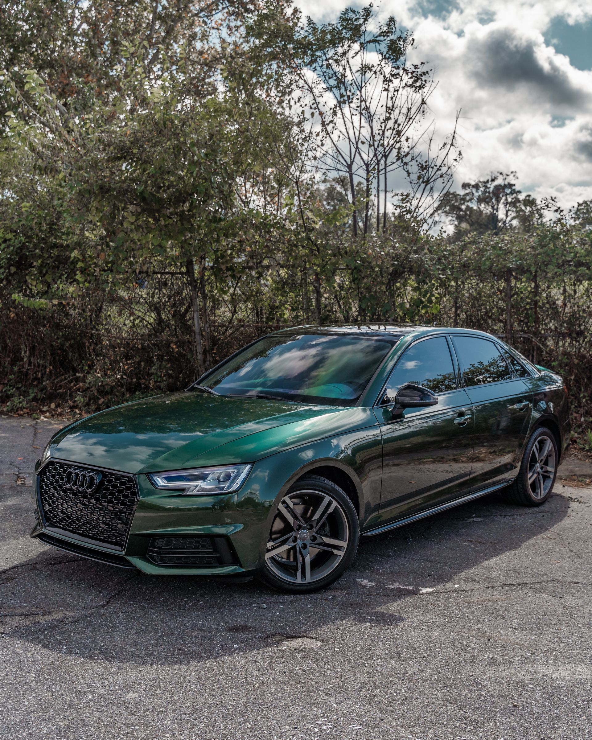 A green audi a4 is parked in a parking lot.