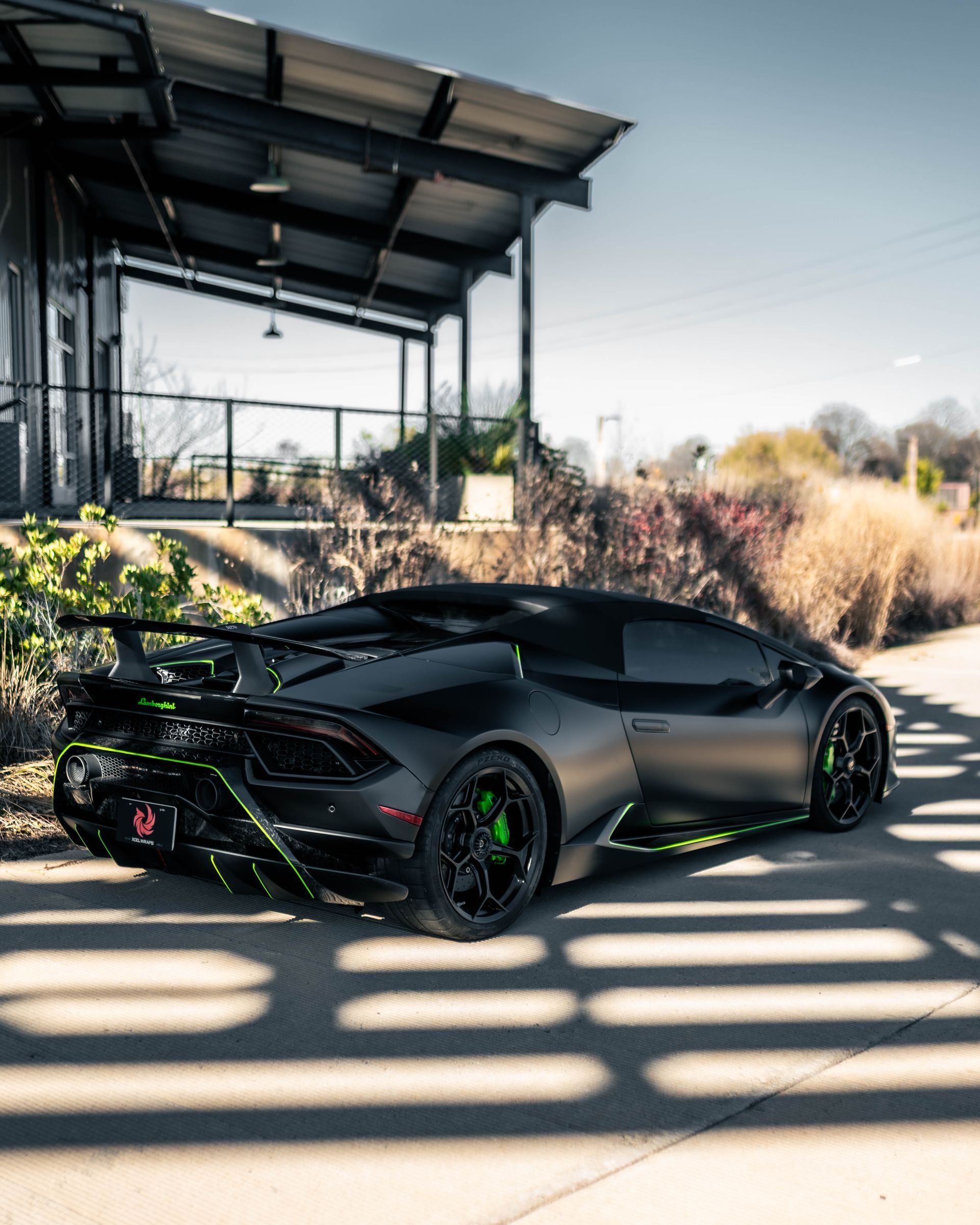 A black lamborghini huracan is parked in front of a building.