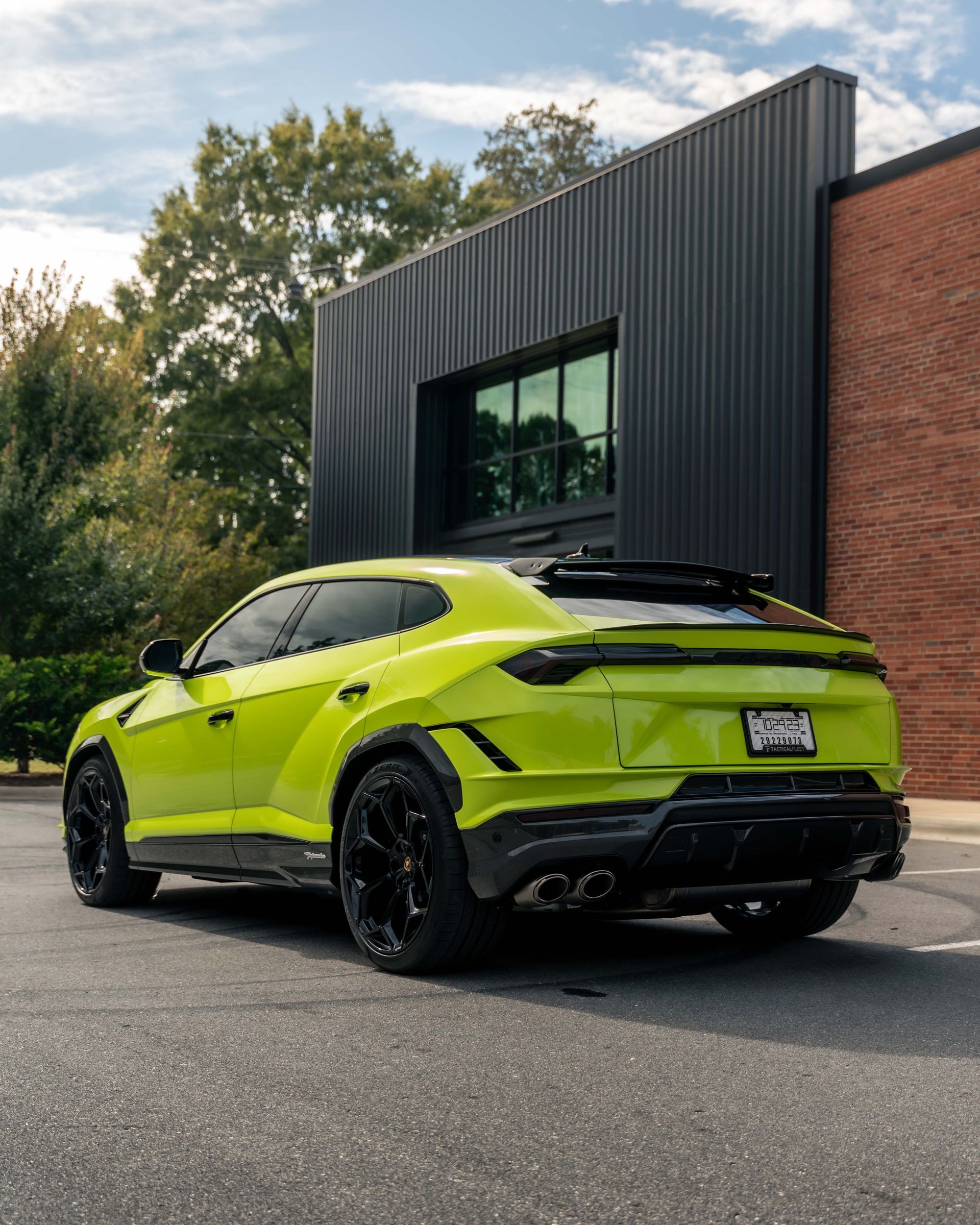 A green lamborghini is parked in front of a building