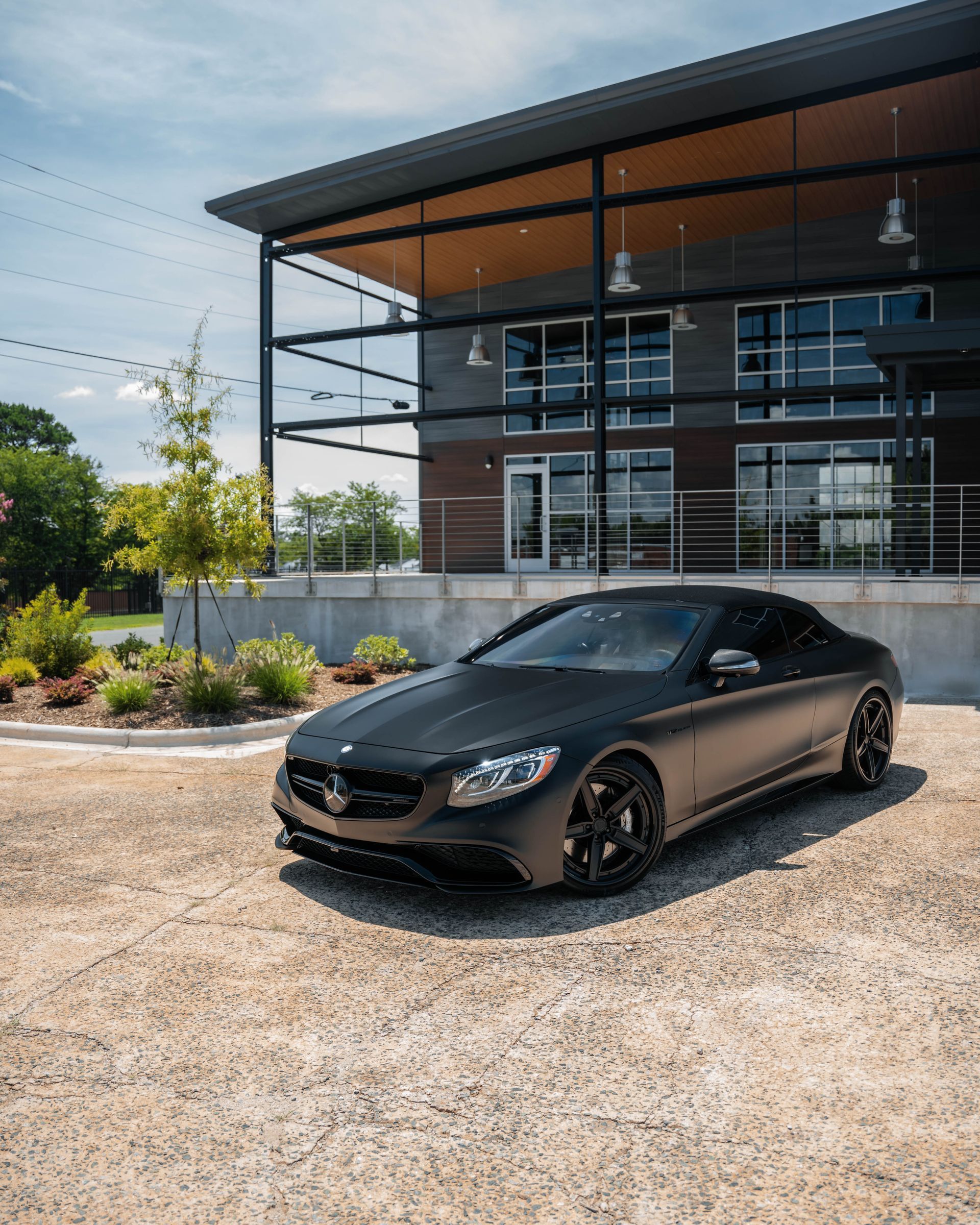 A black car is parked in front of a building