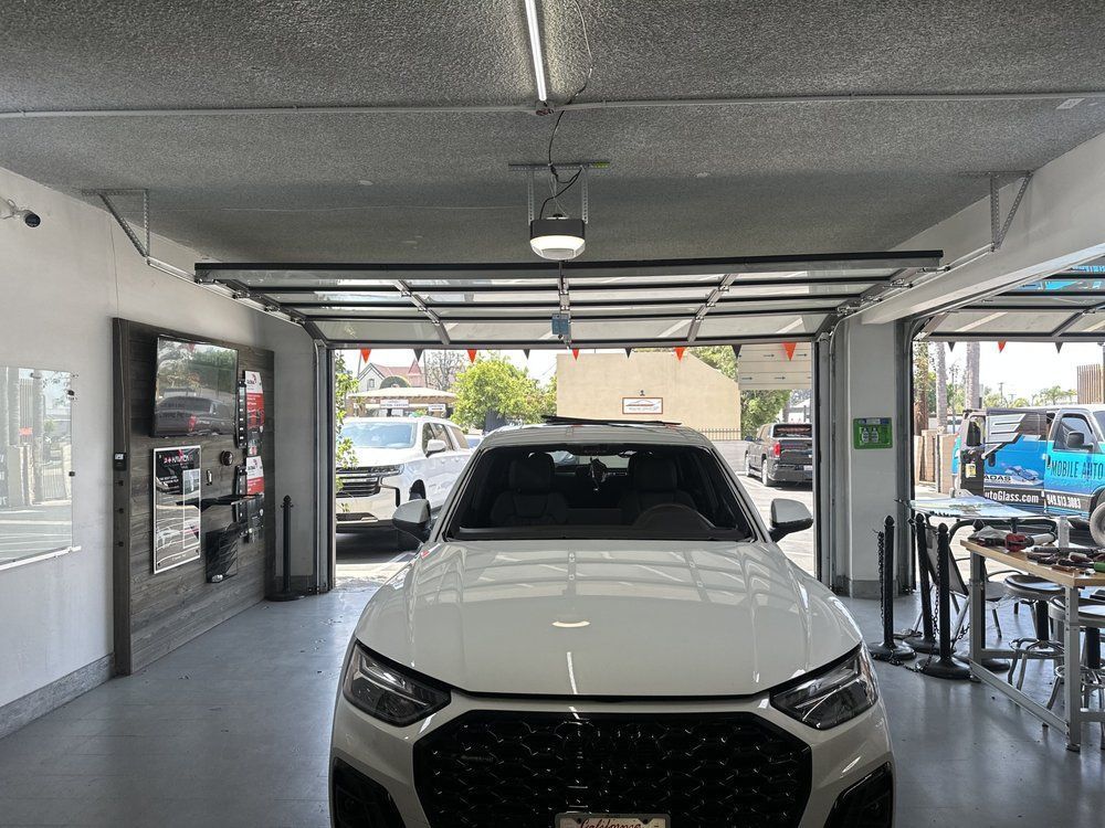 White SUV in a car wash bay under open service doors