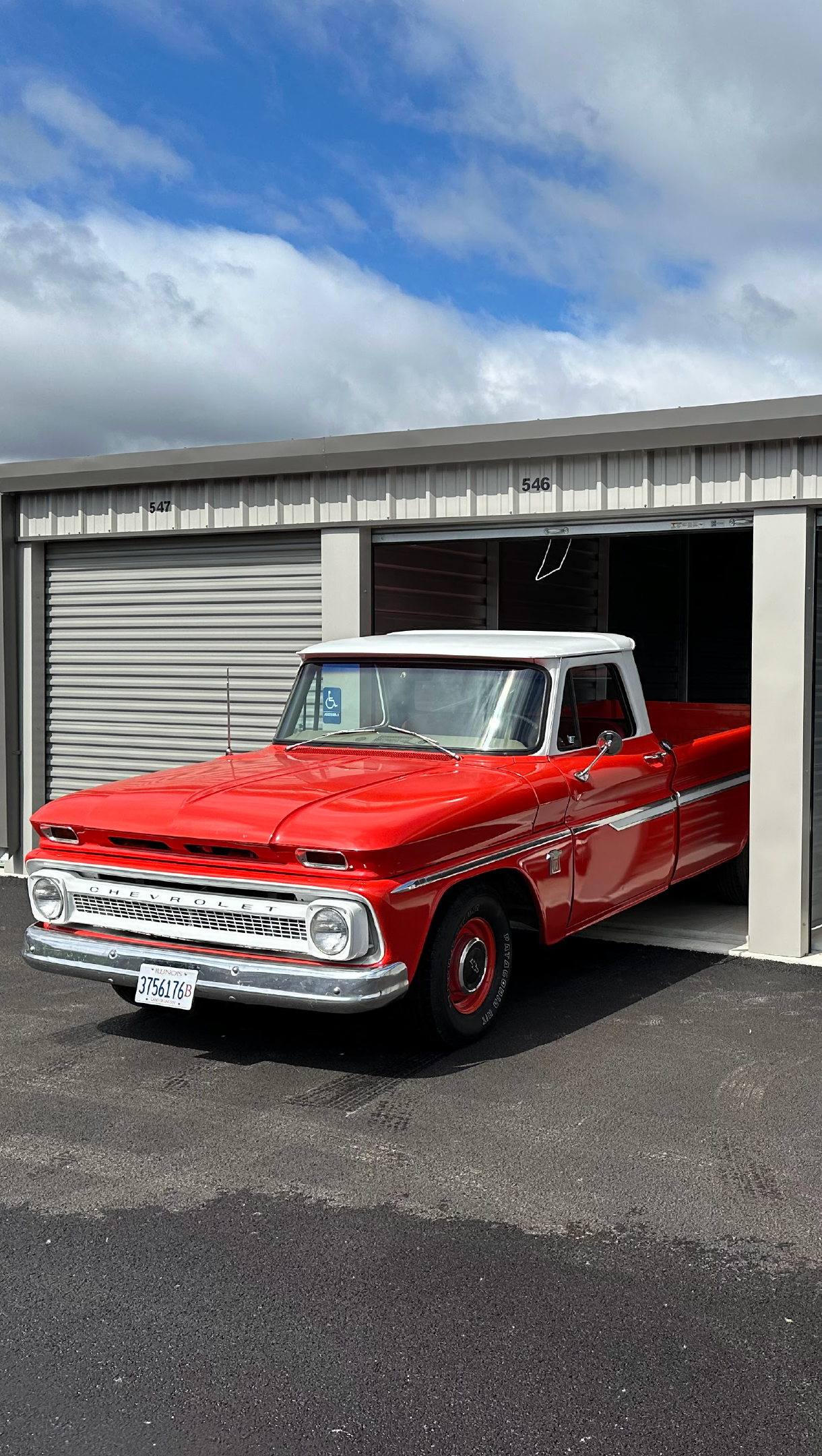 A red pickup truck is parked in a garage.