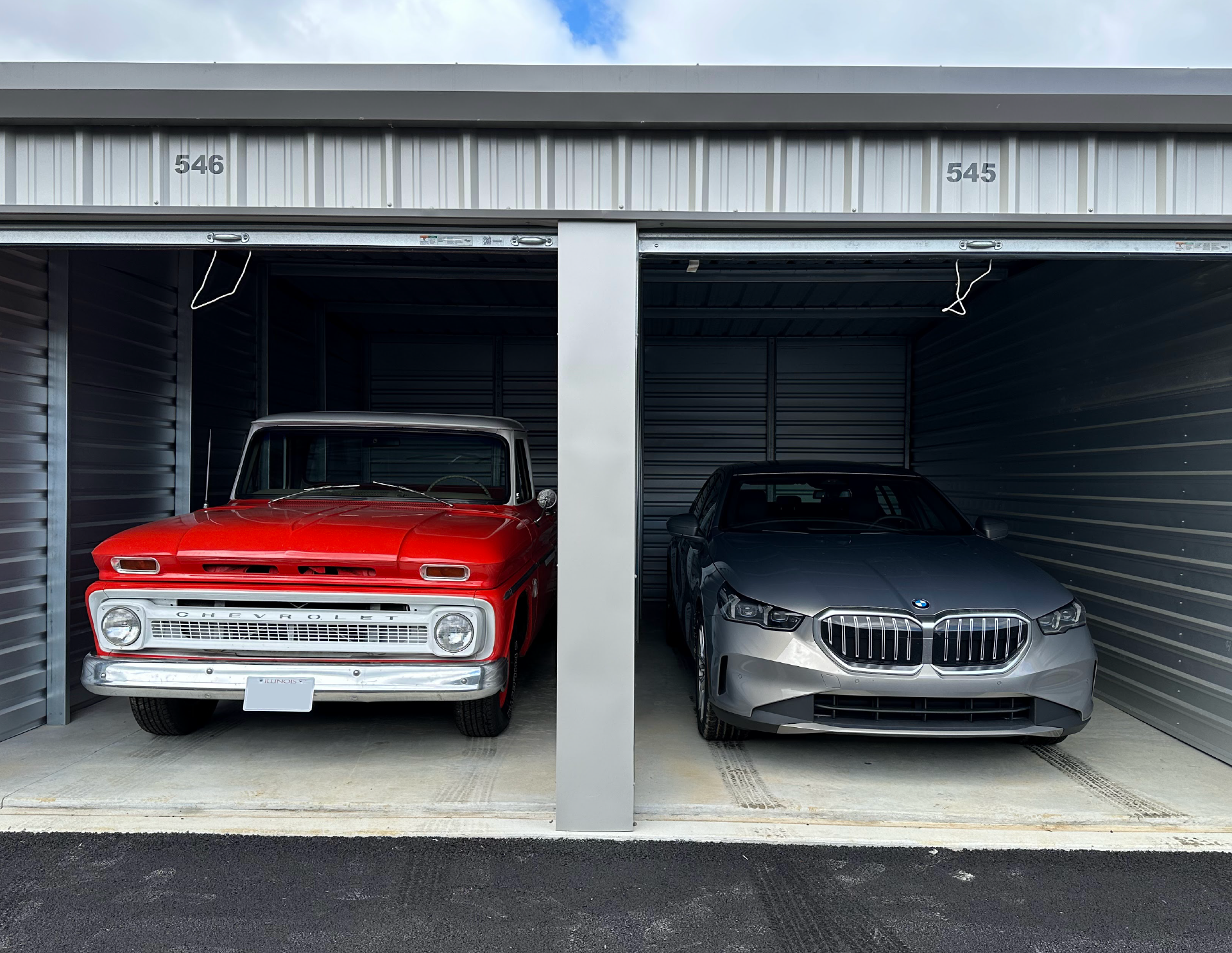 A classic pickup truck and luxury sedan at Open City Self Storage.