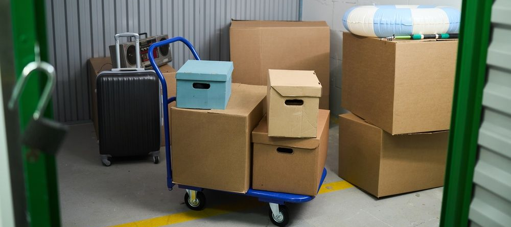 Boxes and luggage on a cart in a storage area with metal walls