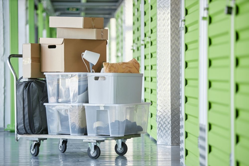 A cart filled with boxes and plastic bins in a storage room.