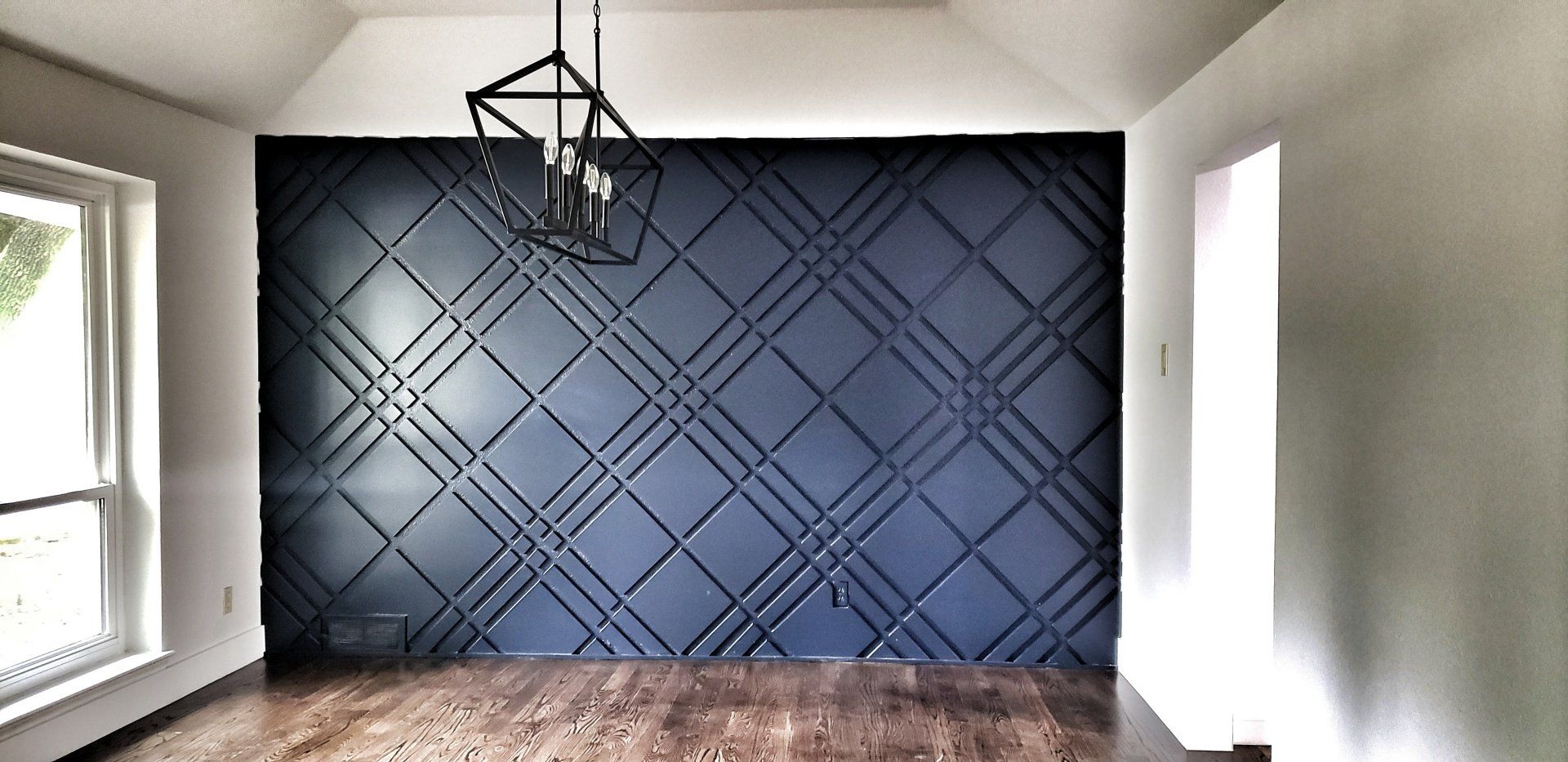 Custom modern accent wall wainscoting with high end chandelier and hardwood floor installation and finishing stain in Southlake Texas