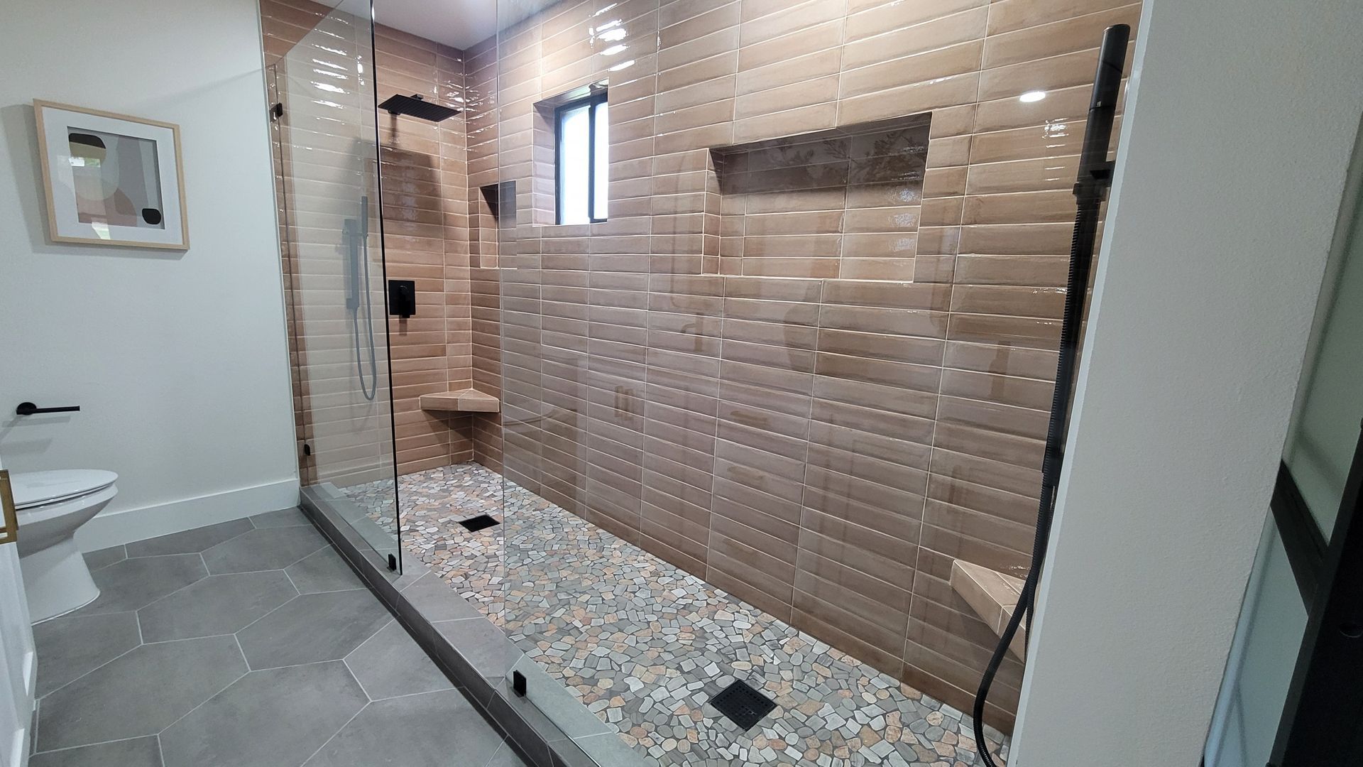Custom shower build and expansion in full service bathroom remodel including custom tile work, frameless shower glass and plumbing installation located in Allen Texas