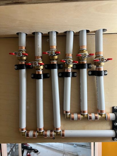 HVAC furnace and water heater in a narrow utility closet with exposed pipes and ducts