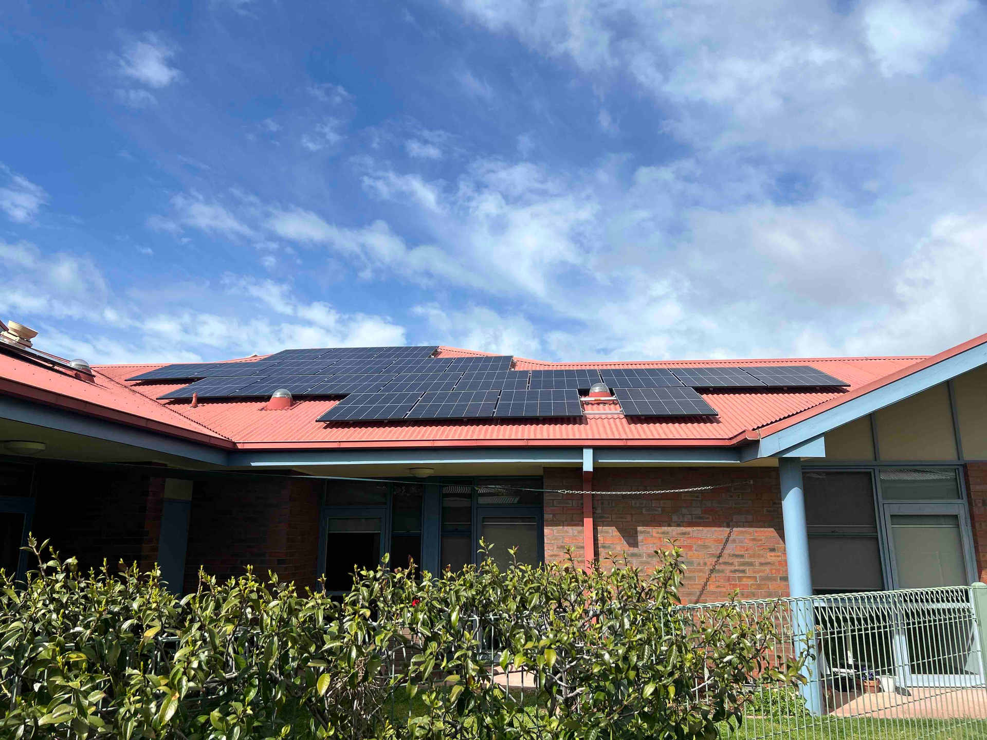 solar installation for grampians health on a red metal roof around skylights