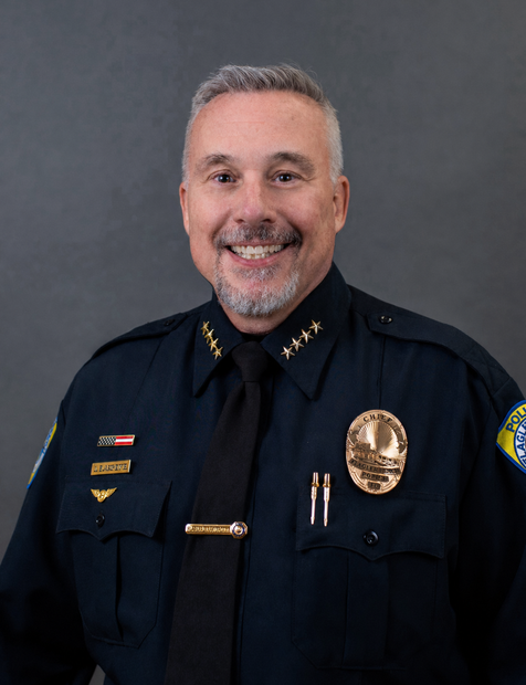 Uniformed police officer smiling against a gray studio backdrop