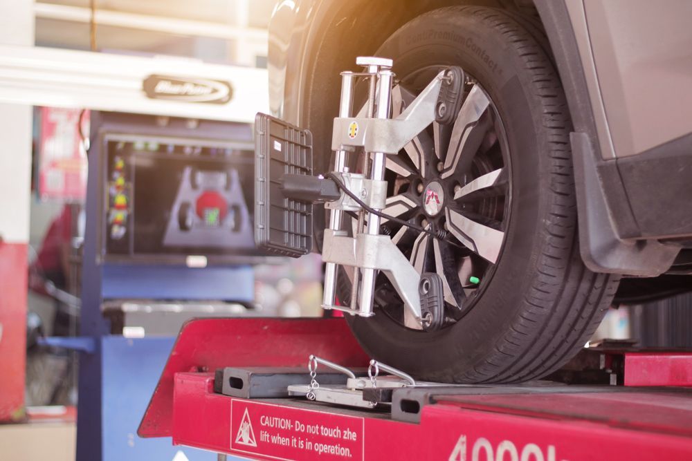 A car is being aligned on a machine in a garage.