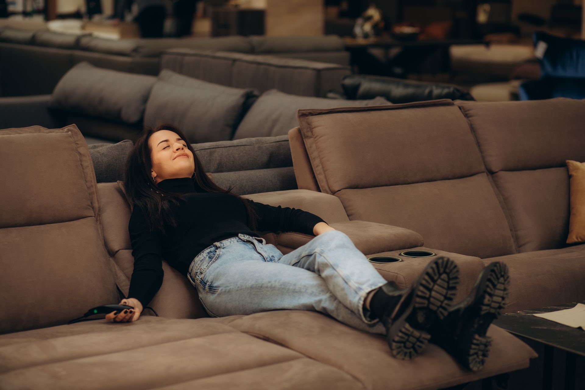 A woman is sitting on an electric recliner.