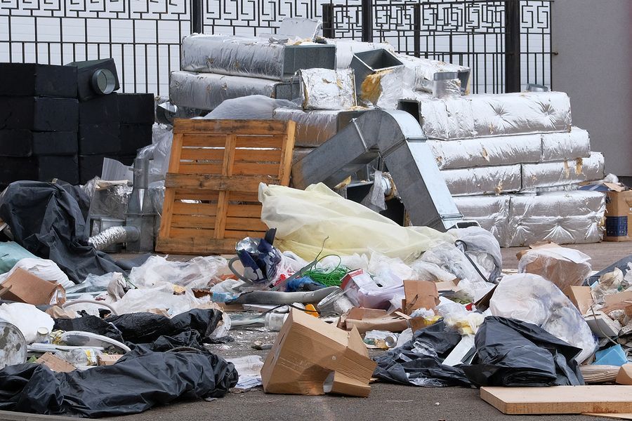 a pile of trash sitting next to a metal fence