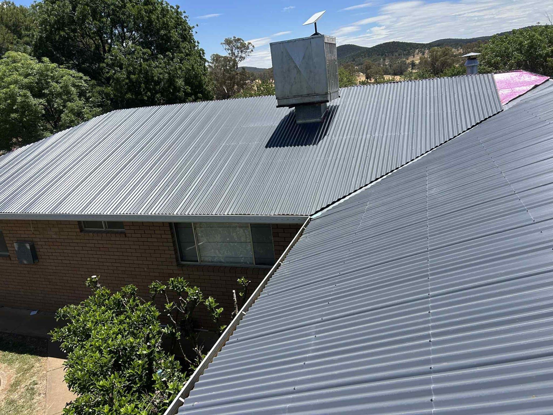Worker on a Tiled Roof Using a Safety Harness Near a Skylight — Hinch Plumbing In Breakwater, VIC