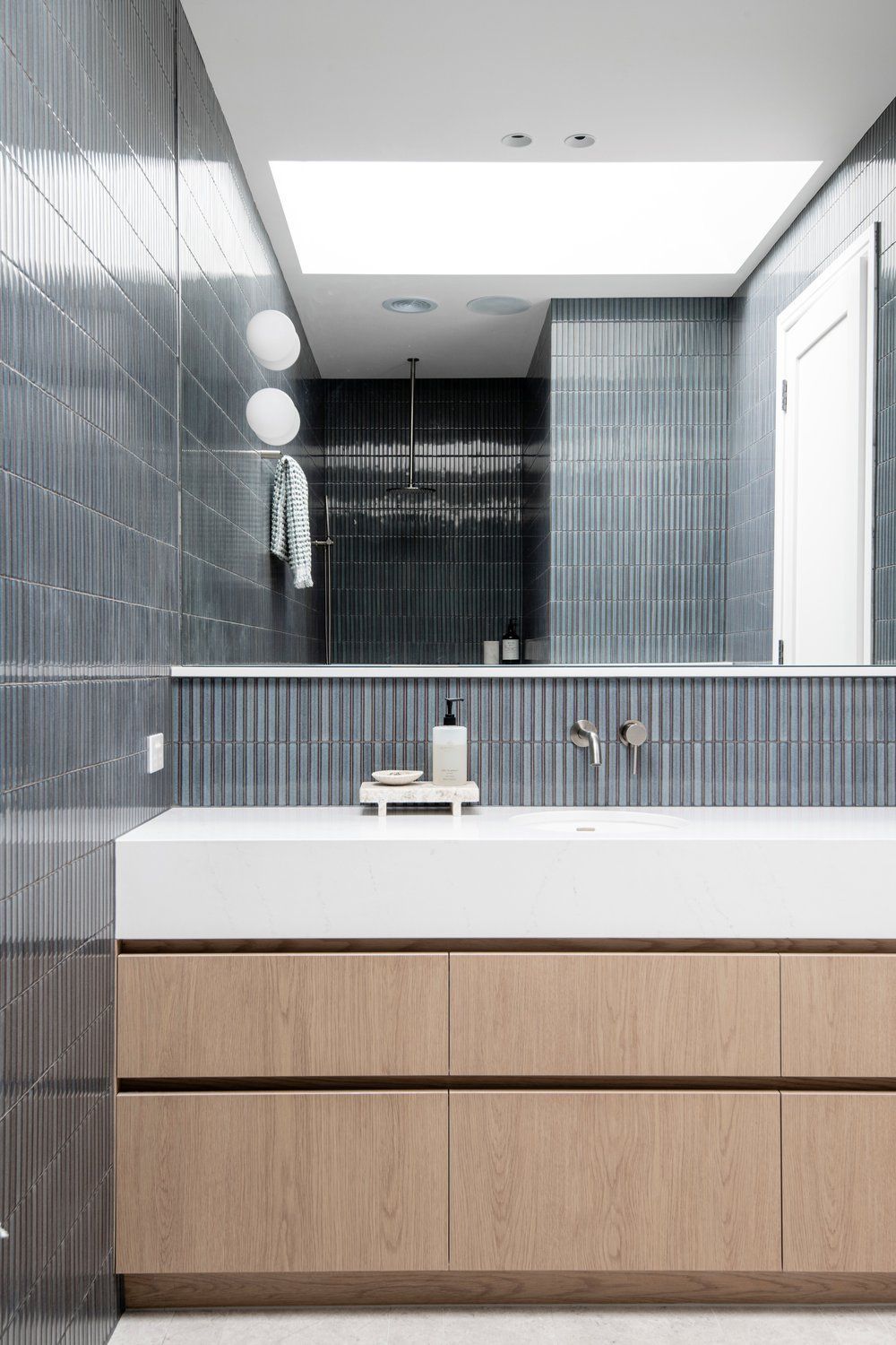 Modern Bathroom Vanity With White Sink, Wood Cabinets, Mirror, and Tiled Walls — Hinch Plumbing In Breakwater, VIC