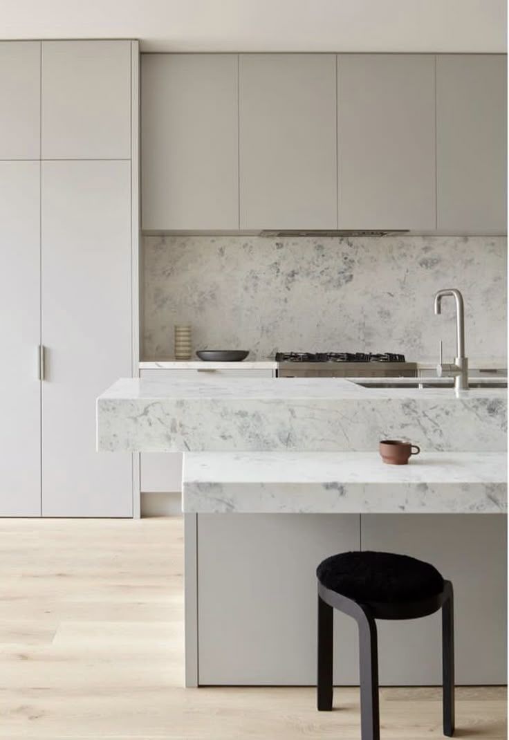 Minimalist White Kitchen With Marble Island, Black Stool, and Built-in Cabinets — Hinch Plumbing In Breakwater, VIC