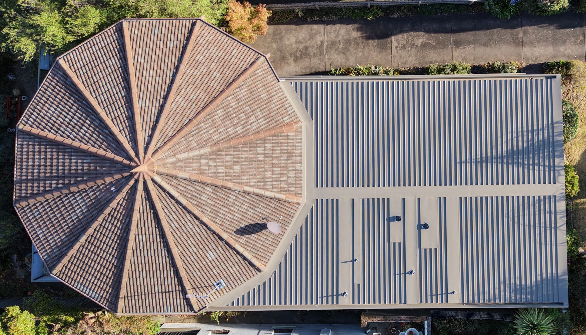 Aerial View of a Circular Tiled Roof Beside a Rectangular Corrugated Metal Roof — Hinch Plumbing In Breakwater, VIC