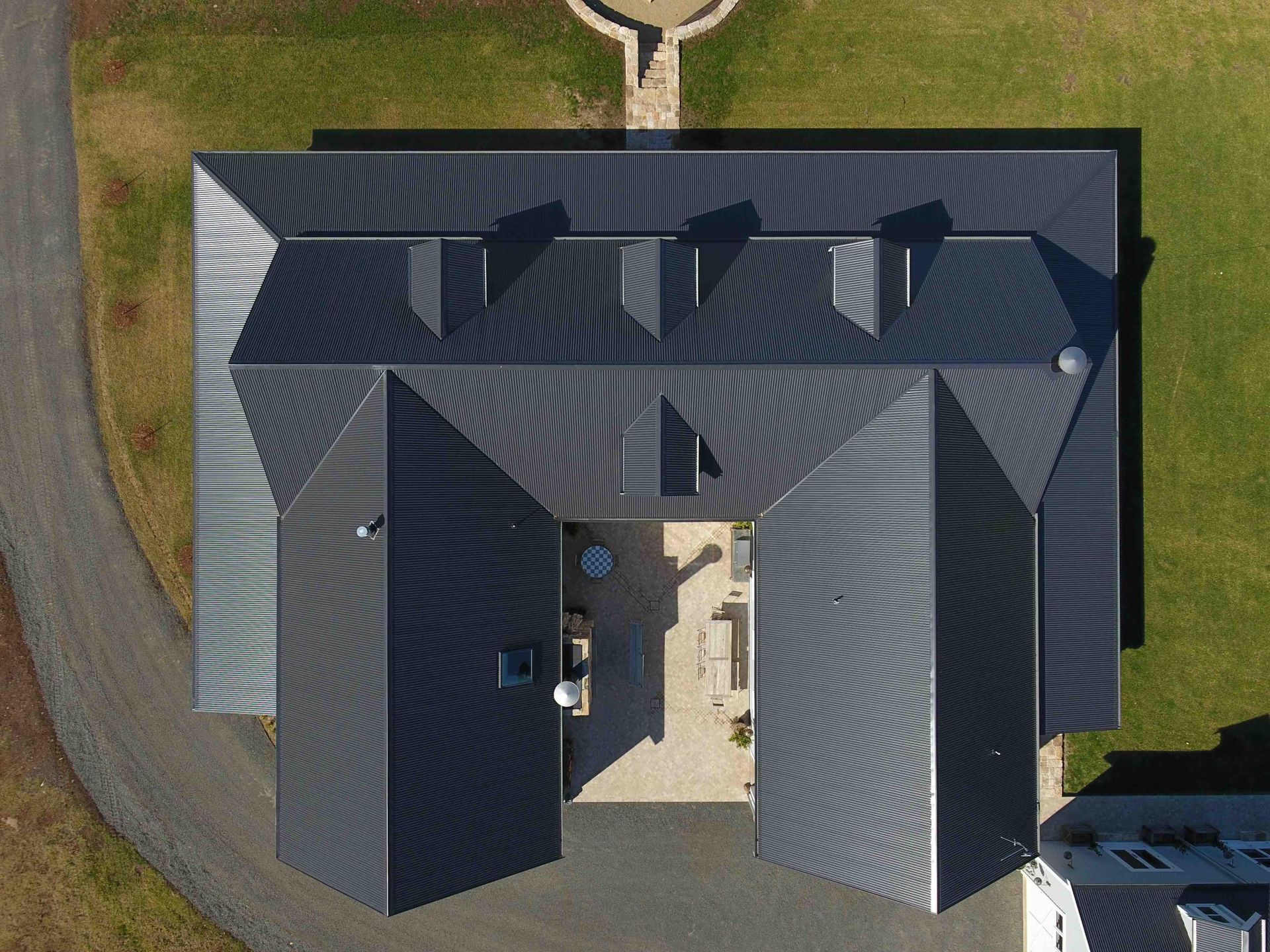 Aerial View of a Dark-roofed House With a Central Courtyard and Surrounding Driveway — Hinch Plumbing In Breakwater, VIC