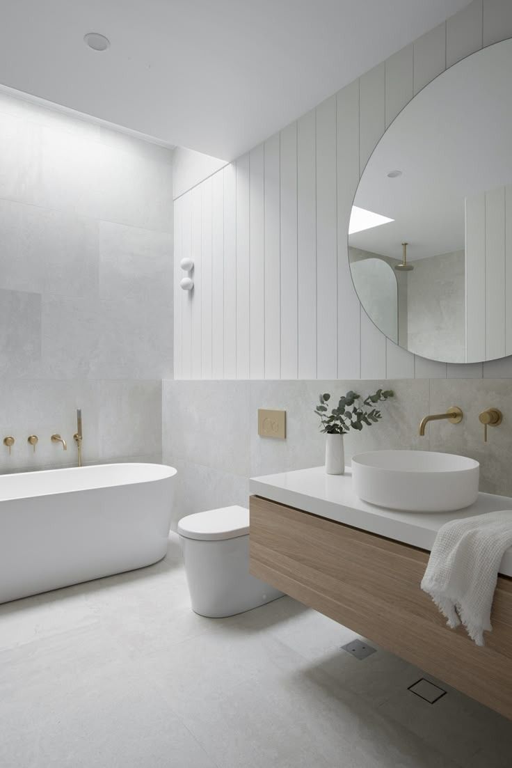 Minimalist White Bathroom With Freestanding Tub, Wood Vanity, Round Mirror — Hinch Plumbing In Breakwater, VIC