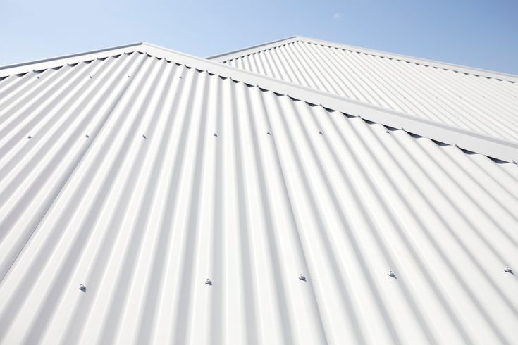 White corrugated metal roof panels seen from below against a blue sky — Hinch Plumbing In Breakwater, VIC