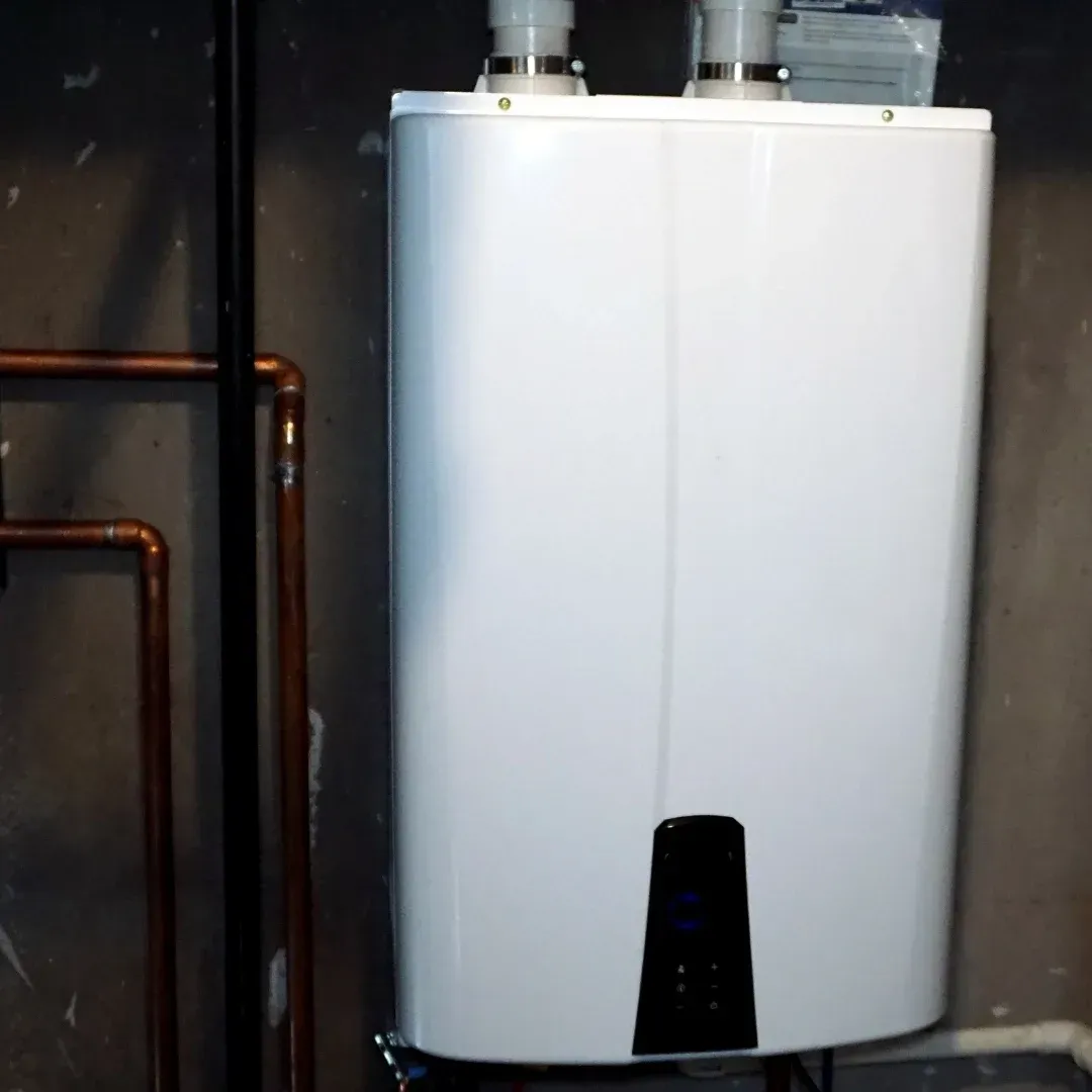 Water heater with pipes in a narrow utility room.