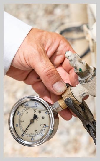 A person is holding a pressure gauge in their hand