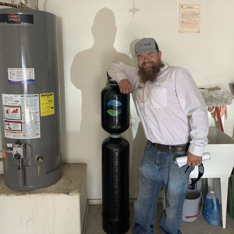 A man standing next to a water heater that says 220 on it