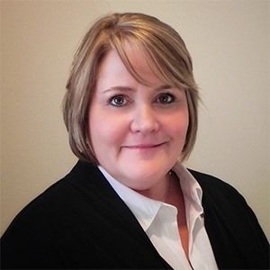Cheri Stout wearing a black jacket and white shirt smiles for the camera